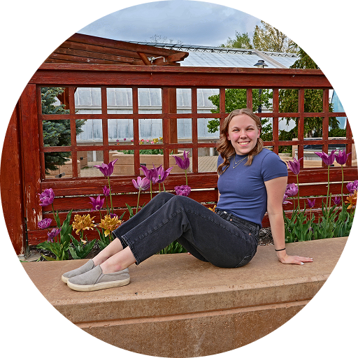 Hannah Stortz sitting outside beside a garden
